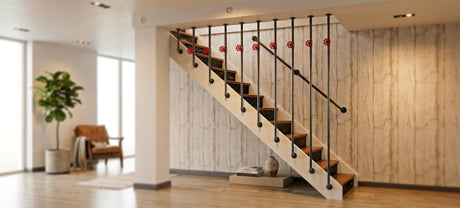Garde-corps d'escalier industriel en tuyaux acier noir et raccords fonte noire avec volants rouges décoratifs