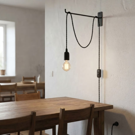 Lampe baladeuse en câble textile torsadé suspendue au-dessus d'une table