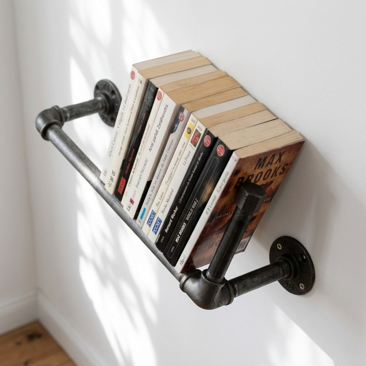 Gietijzeren wandboekenrek op een lichte muur met pockets, sfeerbeeld