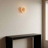 E27 led-donutlamp van rookglas, Ø 195 mm, brandend als wandlamp in een sobere woonkamer