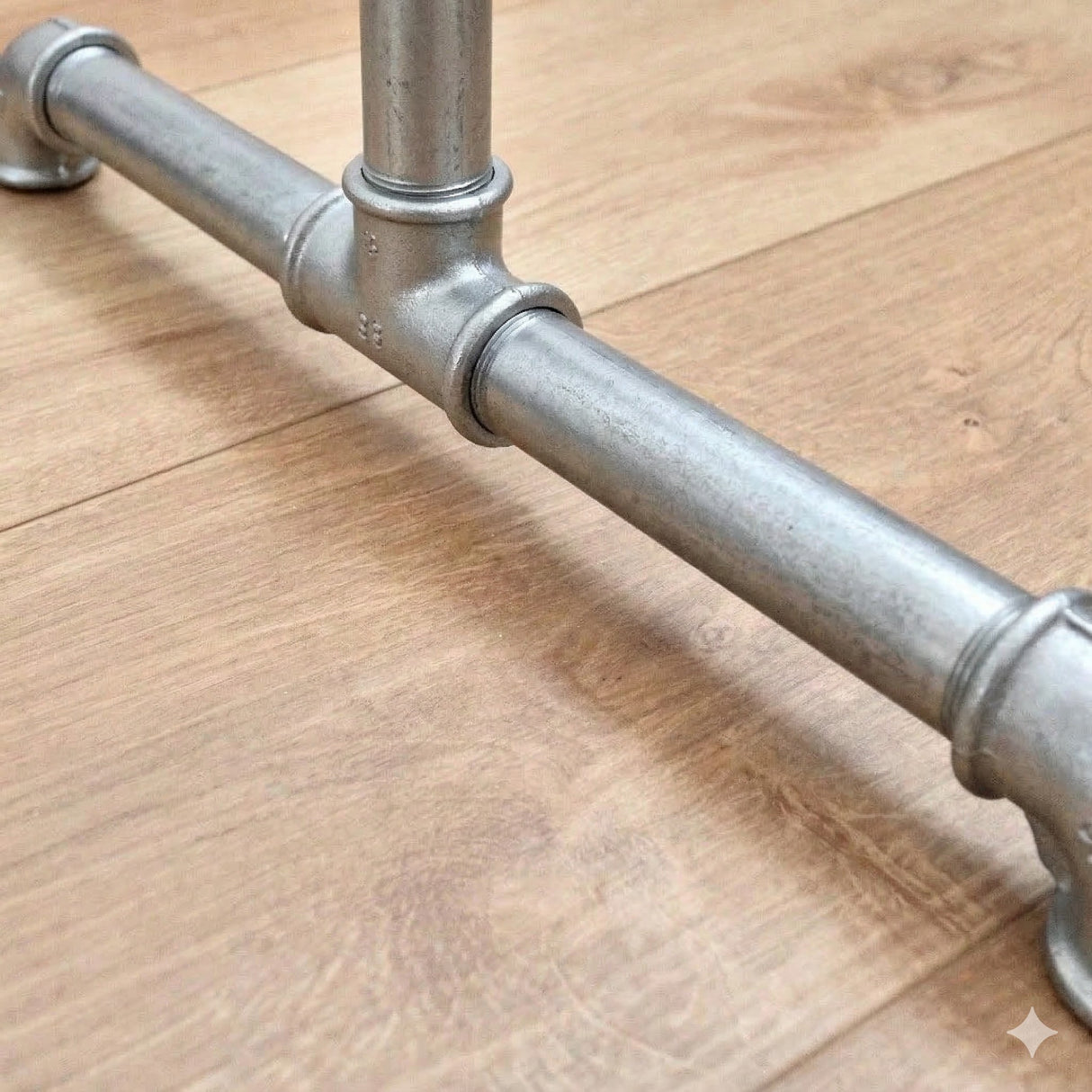 Detail van het voetstuk van het gegalvaniseerde kledingrek met gietijzeren fittingen en schroefdraadbuizen