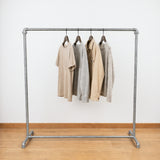 Industriële gegalvaniseerde kledingrek geladen met kleding aan hangers